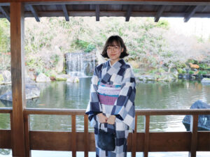 好古園の池を背景に記念撮影する昌原市からの派遣生さん